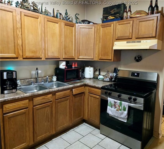 kitchen with a sink, under cabinet range hood, brown cabinetry, stainless steel electric range, and light tile patterned flooring