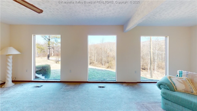 unfurnished living room featuring carpet floors and a textured ceiling