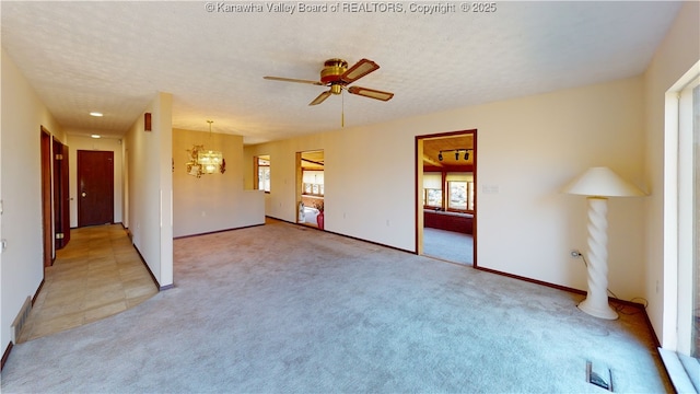 empty room with ceiling fan, light colored carpet, and a textured ceiling