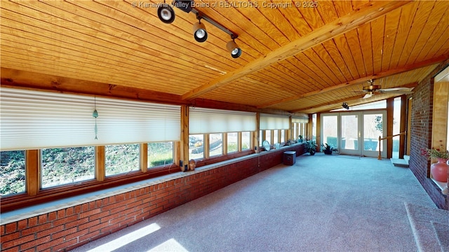 unfurnished sunroom featuring lofted ceiling, a healthy amount of sunlight, wooden ceiling, and ceiling fan