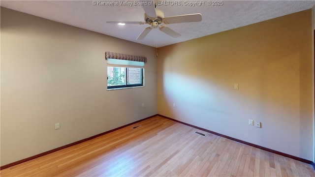 empty room with a textured ceiling, light hardwood / wood-style flooring, and ceiling fan