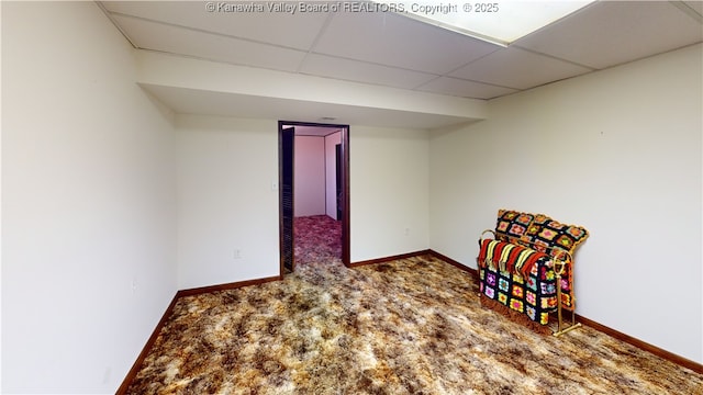 interior space with a paneled ceiling and carpet flooring