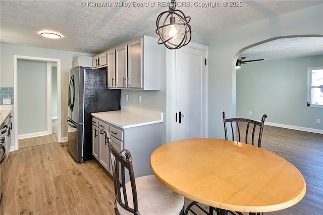 kitchen featuring decorative light fixtures, light hardwood / wood-style floors, a textured ceiling, and gray cabinetry