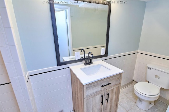 bathroom with tile patterned flooring, vanity, tile walls, and toilet