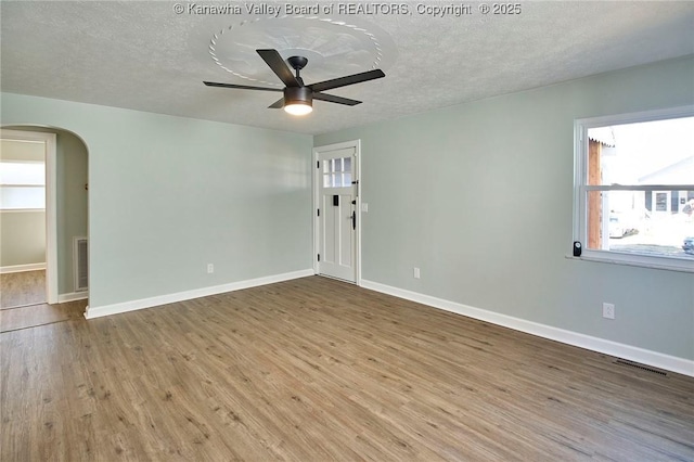 unfurnished room featuring ceiling fan, hardwood / wood-style floors, and a textured ceiling