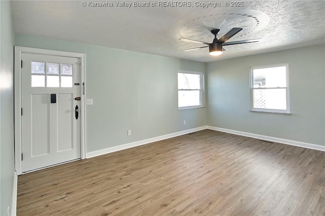 foyer featuring a textured ceiling, light hardwood / wood-style floors, and ceiling fan