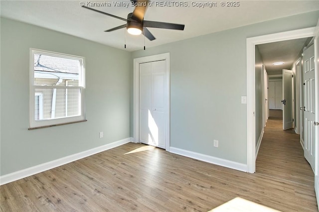 unfurnished bedroom featuring ceiling fan, a closet, and light wood-type flooring