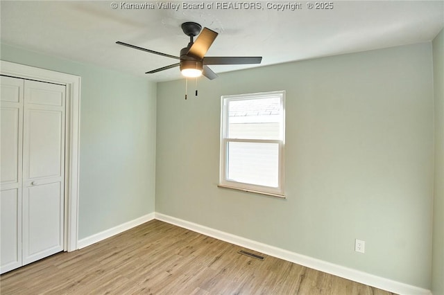 unfurnished bedroom featuring ceiling fan, light hardwood / wood-style floors, and a closet