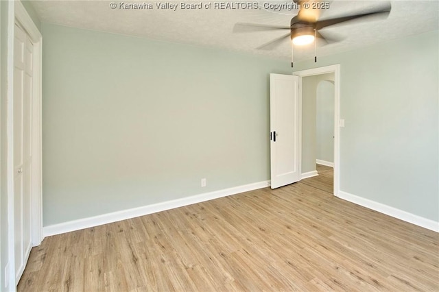 empty room with ceiling fan and light hardwood / wood-style floors