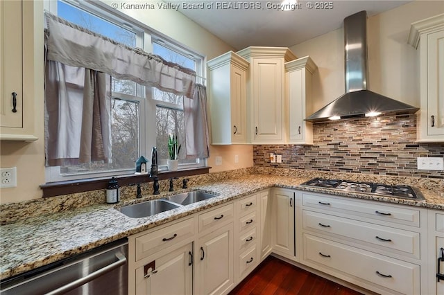 kitchen featuring sink, stainless steel appliances, light stone countertops, decorative backsplash, and wall chimney exhaust hood