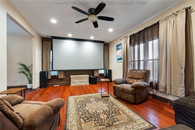 home theater room featuring hardwood / wood-style flooring and ceiling fan