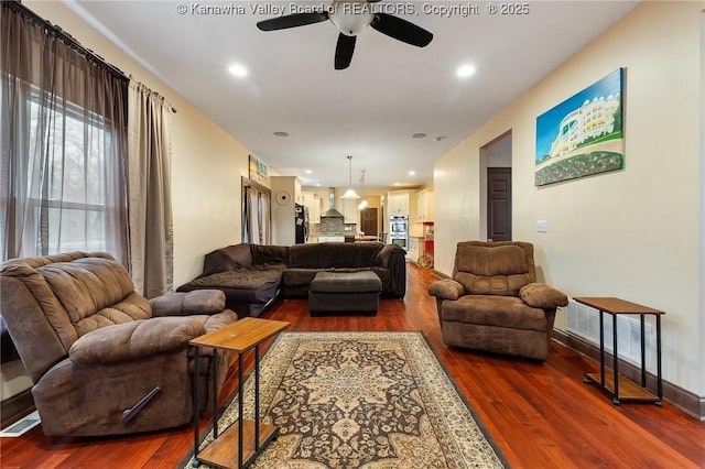 living room with ceiling fan and dark hardwood / wood-style flooring