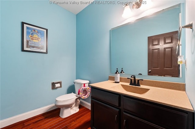 bathroom with vanity, toilet, and hardwood / wood-style floors