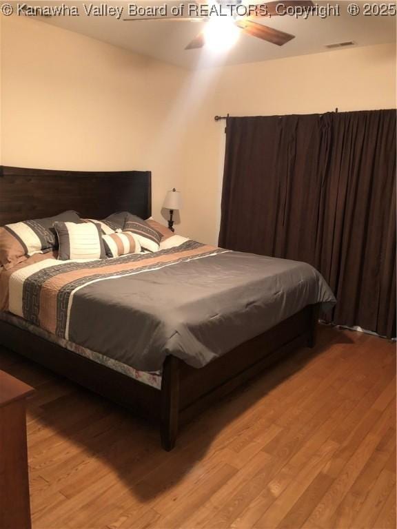 bedroom with light hardwood / wood-style flooring and ceiling fan