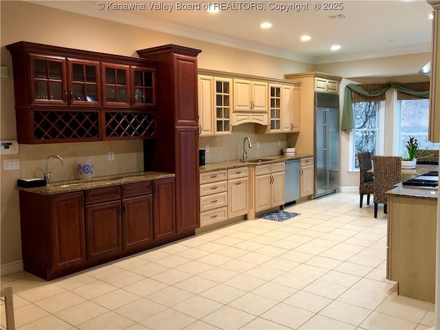 kitchen with tasteful backsplash, cream cabinets, stainless steel appliances, and sink