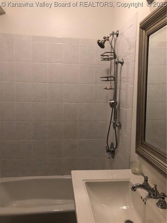 bathroom with sink and a tile shower