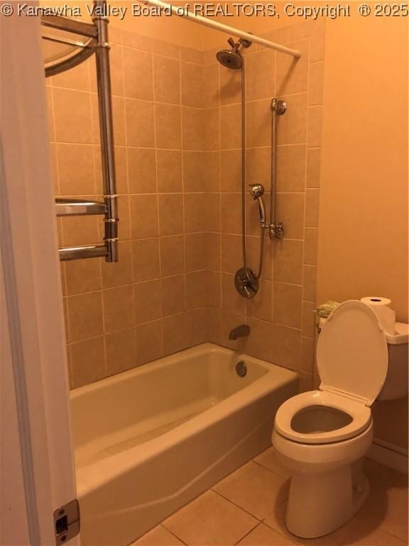 bathroom with tile patterned flooring, tiled shower / bath combo, and toilet