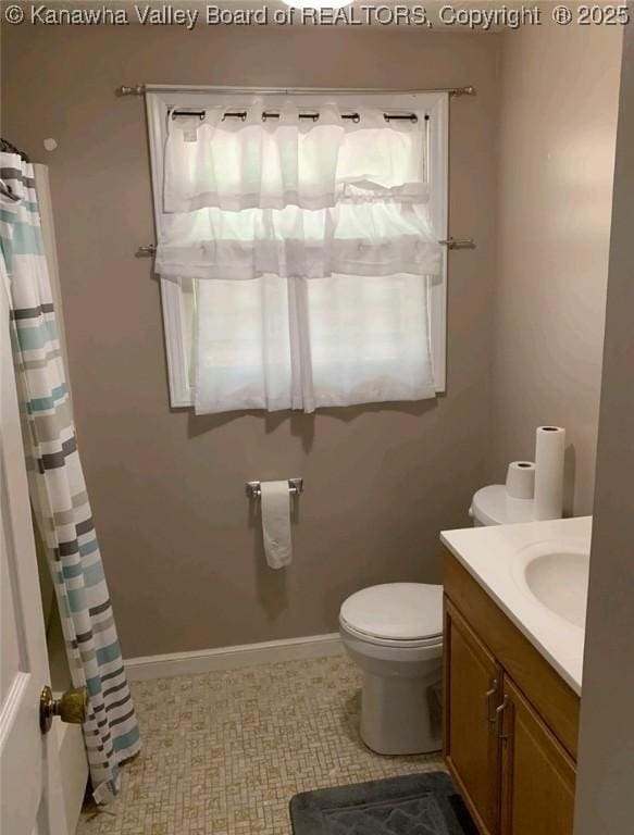 bathroom featuring vanity, toilet, and walk in shower