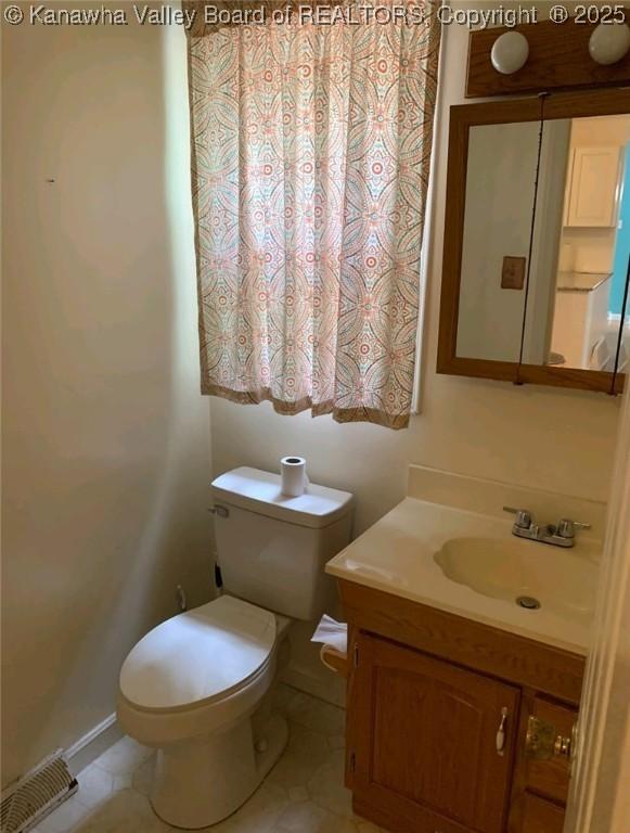 bathroom with vanity, tile patterned floors, and toilet