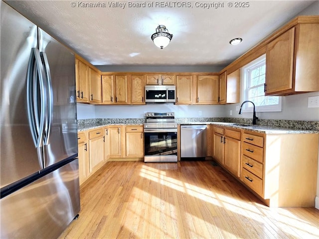 100 Oak Ridge Ln, Huntington, WV 25704 - kitchen featuring stainless steel appliances, light stone countertops, sink, and light hardwood / wood-style flooring
