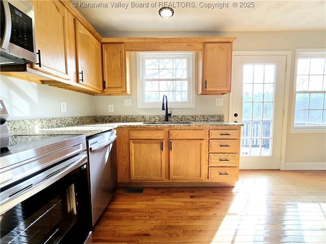 100 Oak Ridge Ln, Huntington, WV 25704 - kitchen featuring sink, stainless steel appliances, light stone countertops, and light wood-type flooring