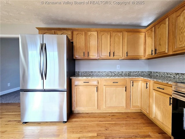 100 Oak Ridge Ln, Huntington, WV 25704 - kitchen with light hardwood / wood-style flooring, stainless steel fridge, light stone countertops, and a textured ceiling