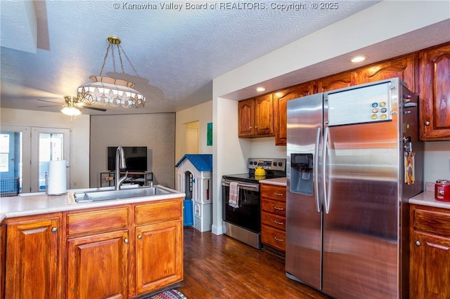 kitchen with appliances with stainless steel finishes, dark hardwood / wood-style floors, pendant lighting, sink, and a textured ceiling