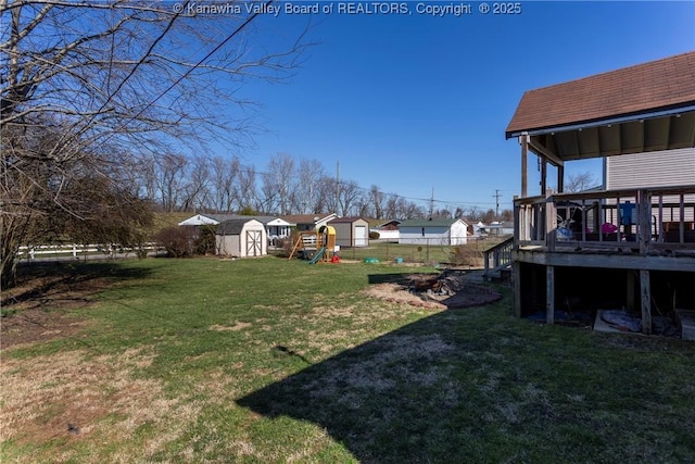 view of yard with a playground, a deck, and a storage shed