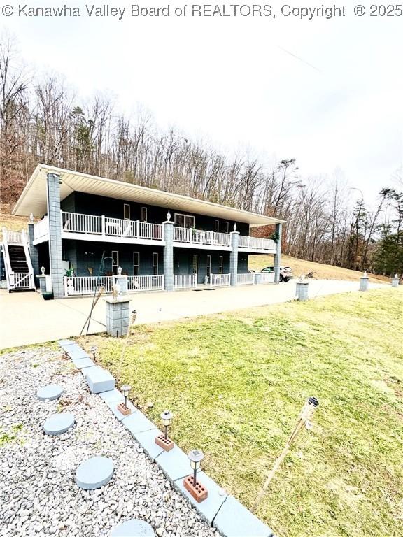 exterior space featuring a lawn, a balcony, and a patio area