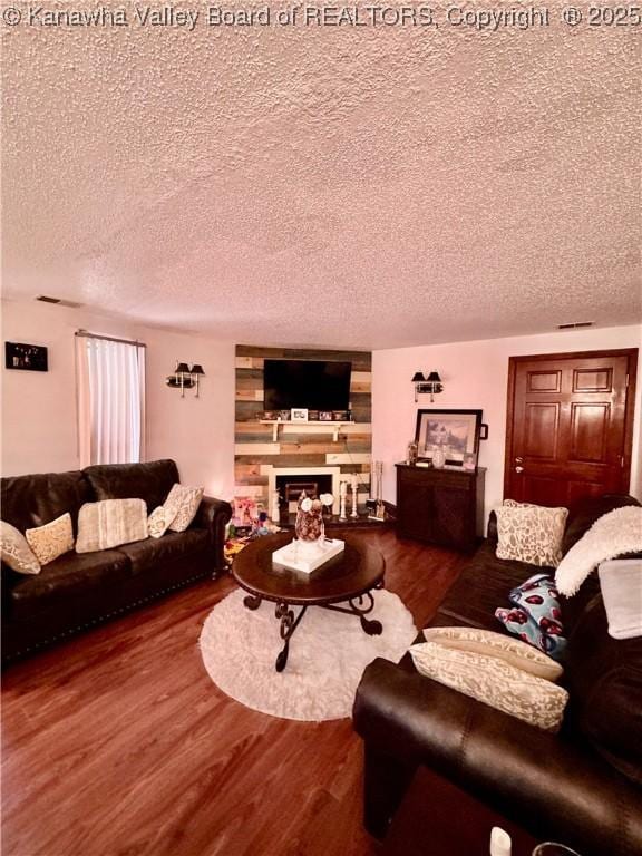 living room featuring wood-type flooring and a textured ceiling