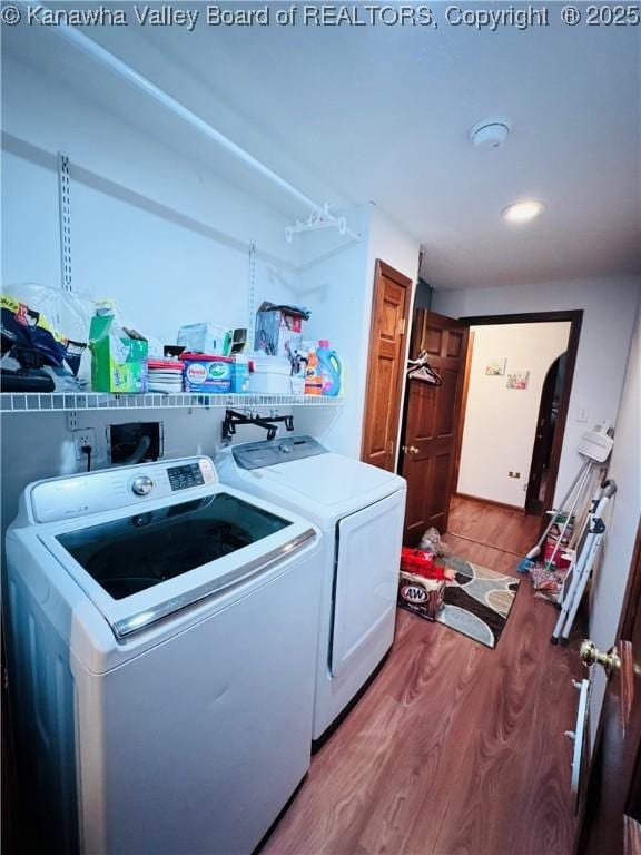 clothes washing area featuring washer and dryer and light hardwood / wood-style flooring