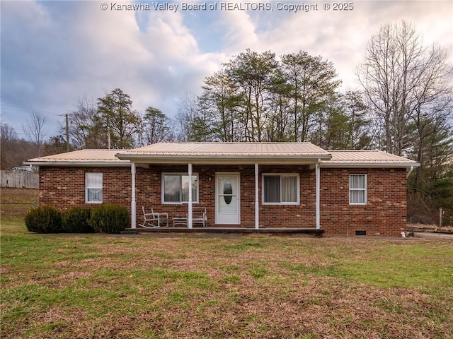 ranch-style home featuring covered porch and a front yard