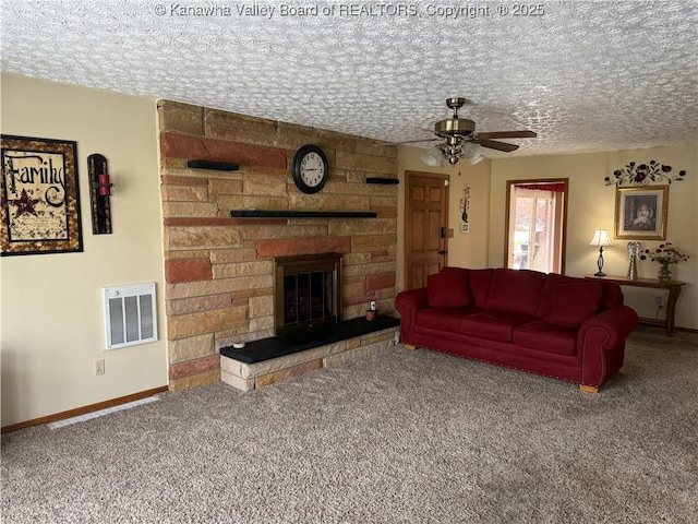 carpeted living room featuring ceiling fan, a textured ceiling, and a fireplace