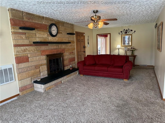 living room featuring ceiling fan, carpet flooring, a textured ceiling, and a fireplace