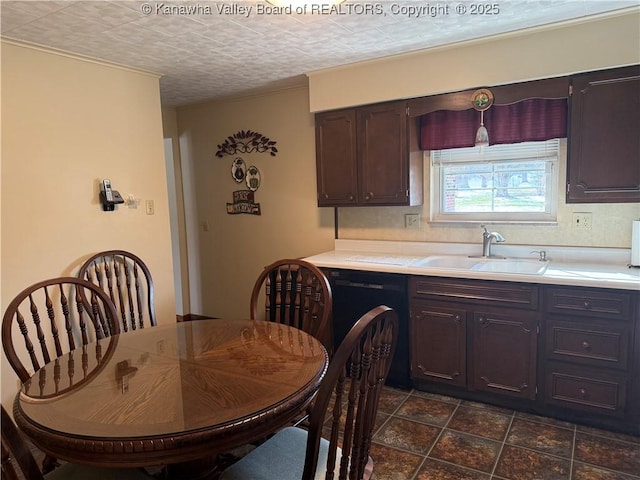 kitchen with dark brown cabinets, sink, and a textured ceiling