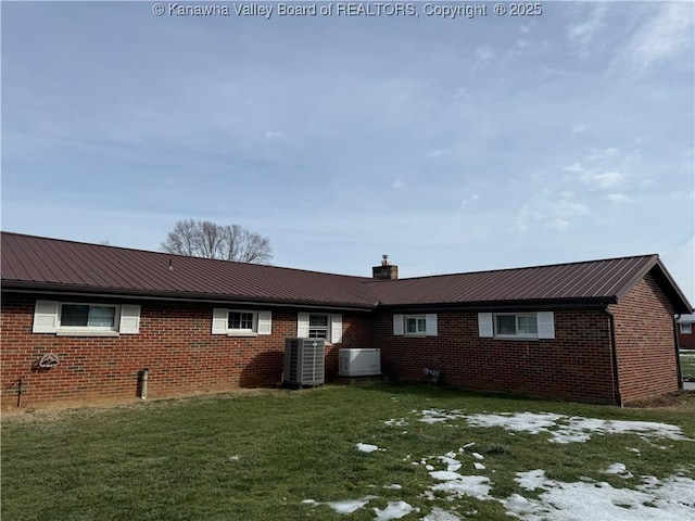 rear view of property with a lawn and central AC