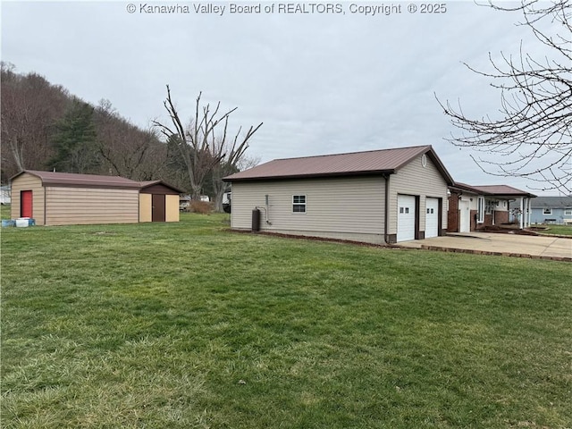 view of yard featuring a storage shed and a garage