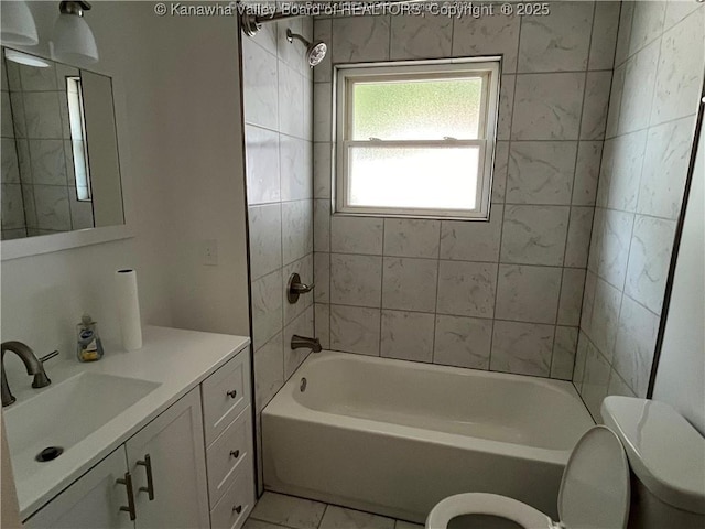 full bathroom featuring tiled shower / bath combo, toilet, and vanity