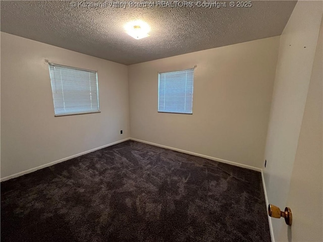 empty room featuring a textured ceiling and dark carpet