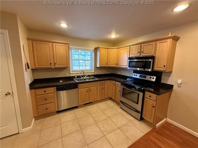 kitchen featuring light tile patterned floors, sink, stainless steel appliances, and light brown cabinetry