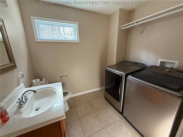 laundry room with light tile patterned floors, sink, and separate washer and dryer