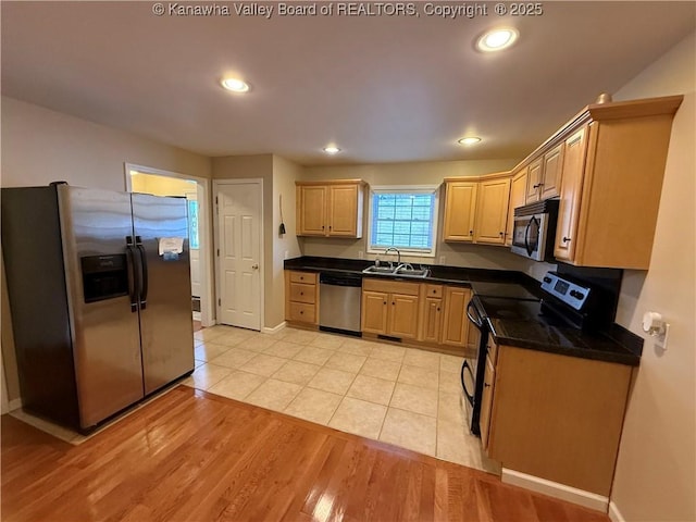 kitchen with sink, stainless steel appliances, light brown cabinetry, and light hardwood / wood-style floors