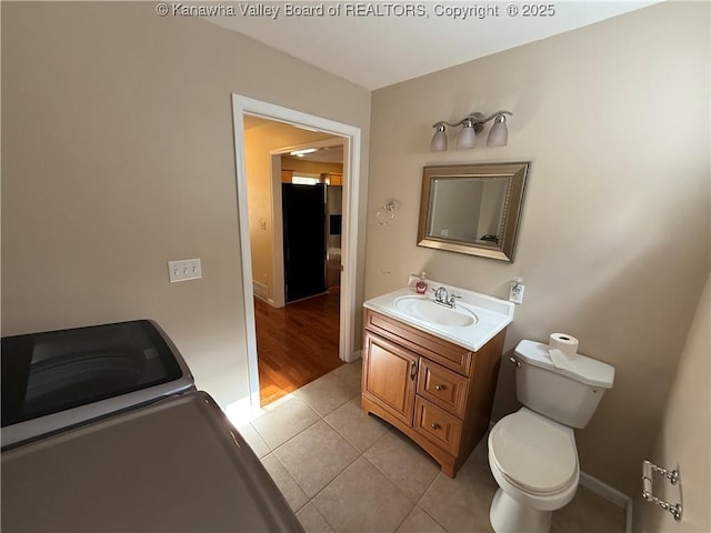 bathroom with toilet, vanity, and tile patterned flooring