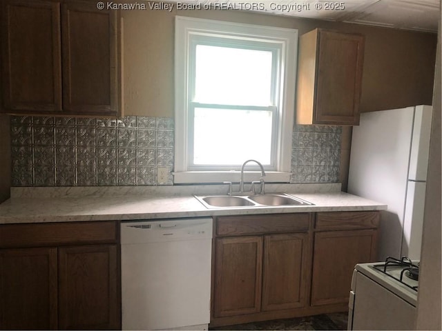 kitchen featuring sink, white appliances, and decorative backsplash