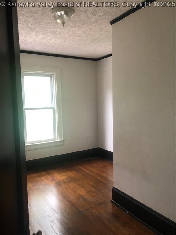 empty room featuring dark wood-type flooring and a textured ceiling