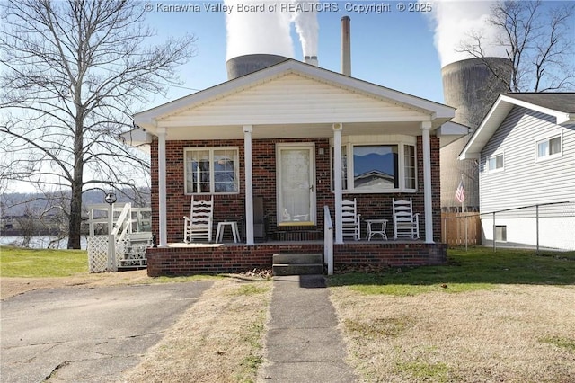 view of front of home with covered porch and a front lawn