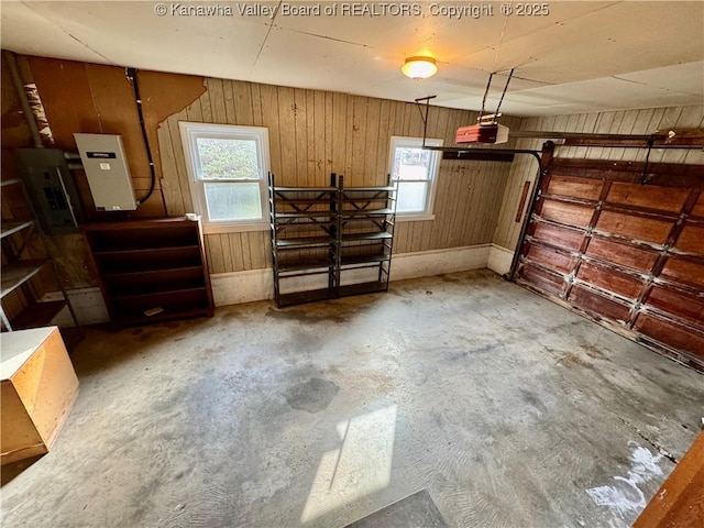 garage with electric panel and wooden walls