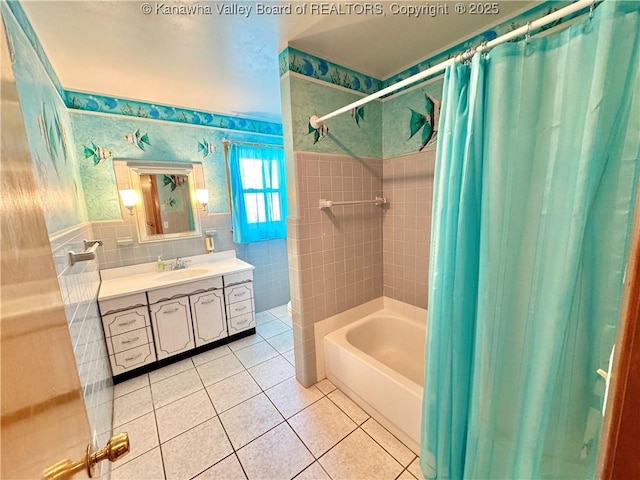 bathroom with tile patterned floors, shower / bath combo with shower curtain, tile walls, and vanity