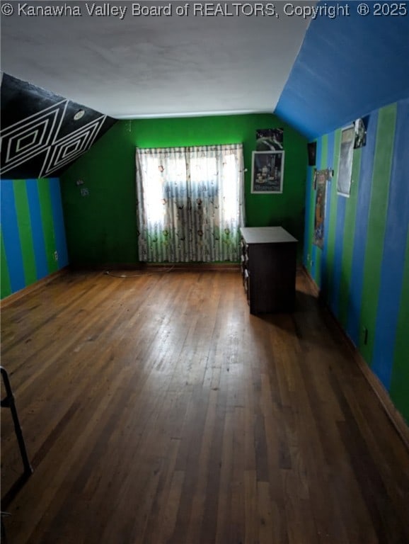 additional living space with dark wood-style floors, vaulted ceiling, and baseboards