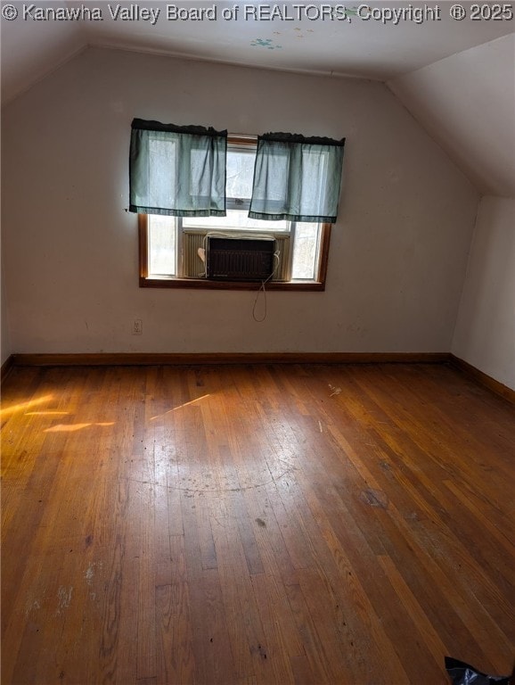 bonus room with lofted ceiling, baseboards, and wood finished floors